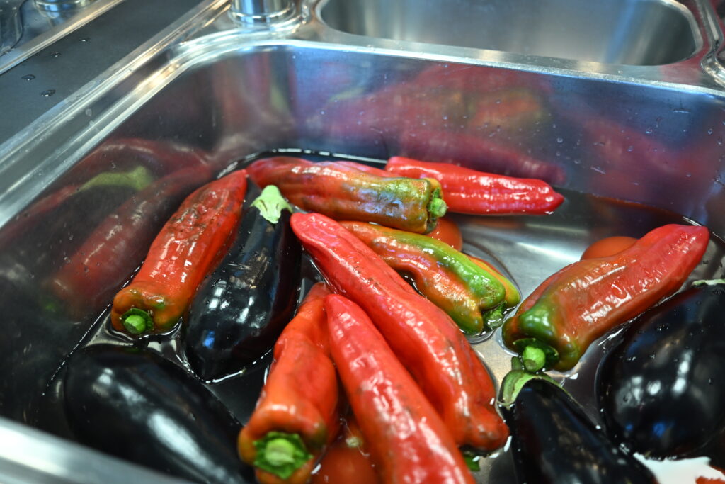 Paprika werden in einer Spüle gewaschen