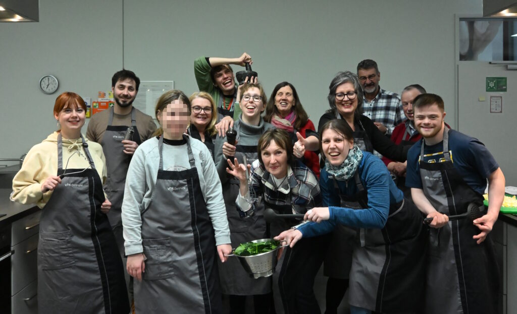 Gruppenbild der Teilnehmer, die viel Spaß beim Kochkurs haben